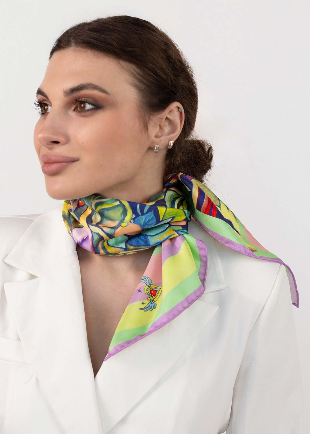 Designer Seidentuch Zauberwald Morgen 65×65 cm um den Hals einer Frau getragen in einem eleganten Outfit.