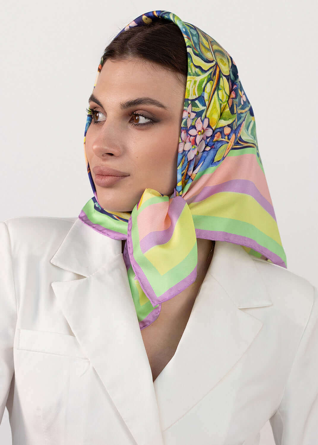 Designer Seidentuch Zauberwald Morgen 65×65 cm: Model trägt den stylischen Seidenschal im bunten Design.