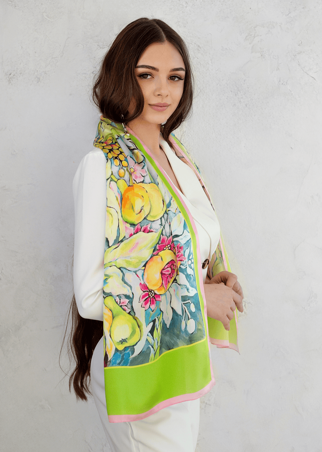 Designer-Seidenschal im Sommerstil mit farbenfrohem Frucht und Blumenmuster in Grün, Gelb und Pink, locker über die Schultern einer eleganten Frau gelegt – exklusives Accessoire von Iryna Feinblatt