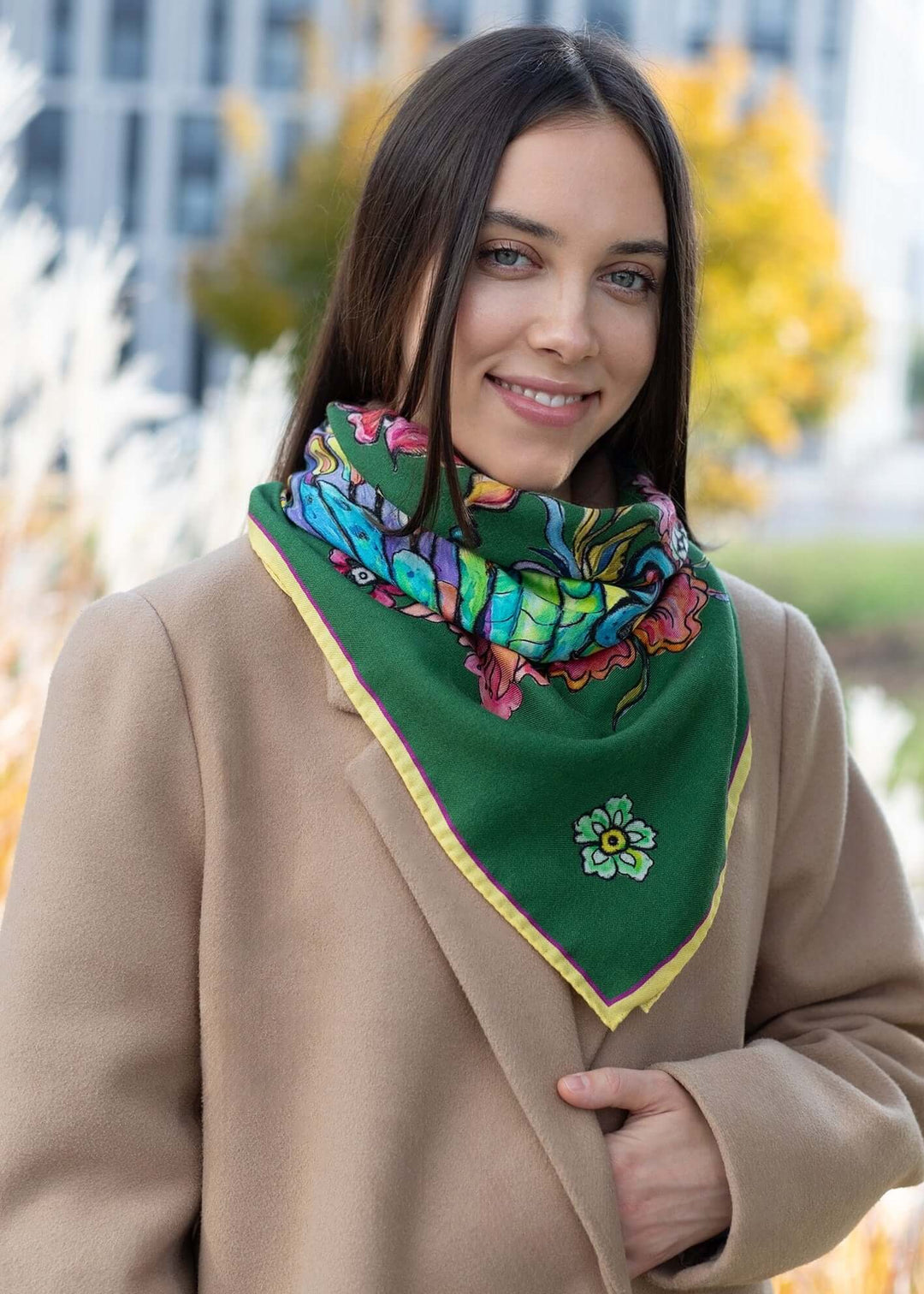 Ein Mädchen in einem grünen Mantel trägt einen Designer Schmetterlingsschal aus Kaschmir, der farblich zu ihrem Outfit passt.