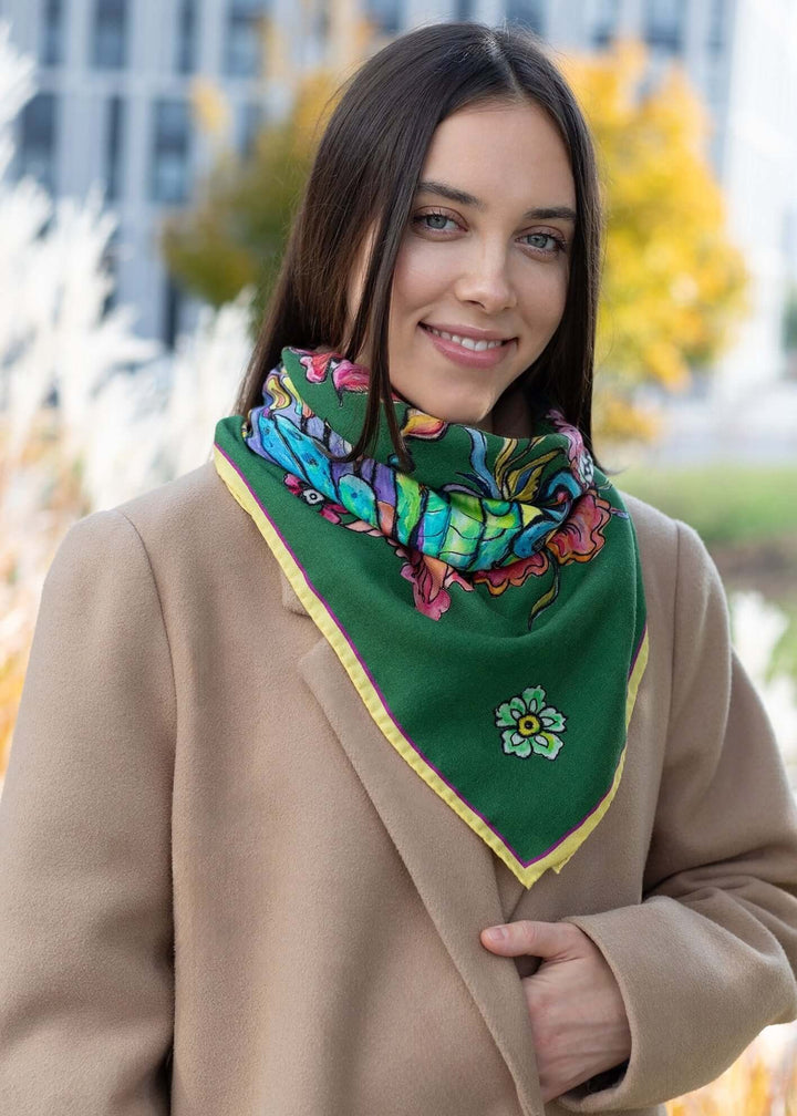 Ein Mädchen in einem grünen Mantel trägt einen Designer Schmetterlingsschal aus Kaschmir, der farblich zu ihrem Outfit passt.
