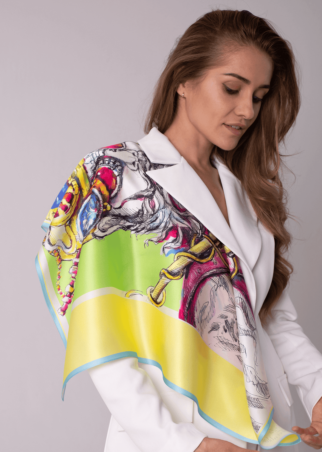 Designer Silk Scarf Traveller in gelb, bunte kunstvolle Details, drapiert an einem Model in elegantem weißen Outfit.