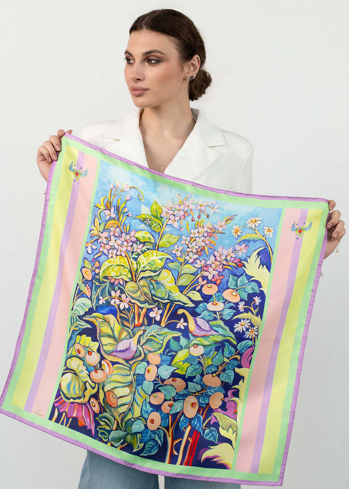 Designer Seidentuch Zauberwald Morgen 65×65 cm mit farbenfrohem Blumen- und Vogelmotiv, elegant präsentiert von Model.