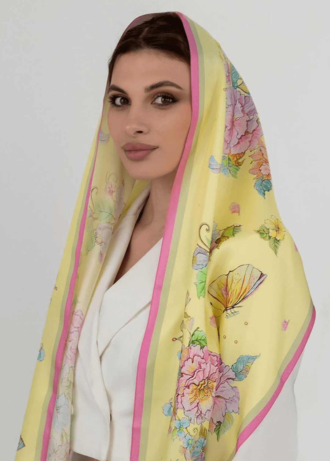 Elegantes Seidenkopftuch in Gelb mit Blumendruck und Schmetterlingen, 40x160 cm, getragen von Model.