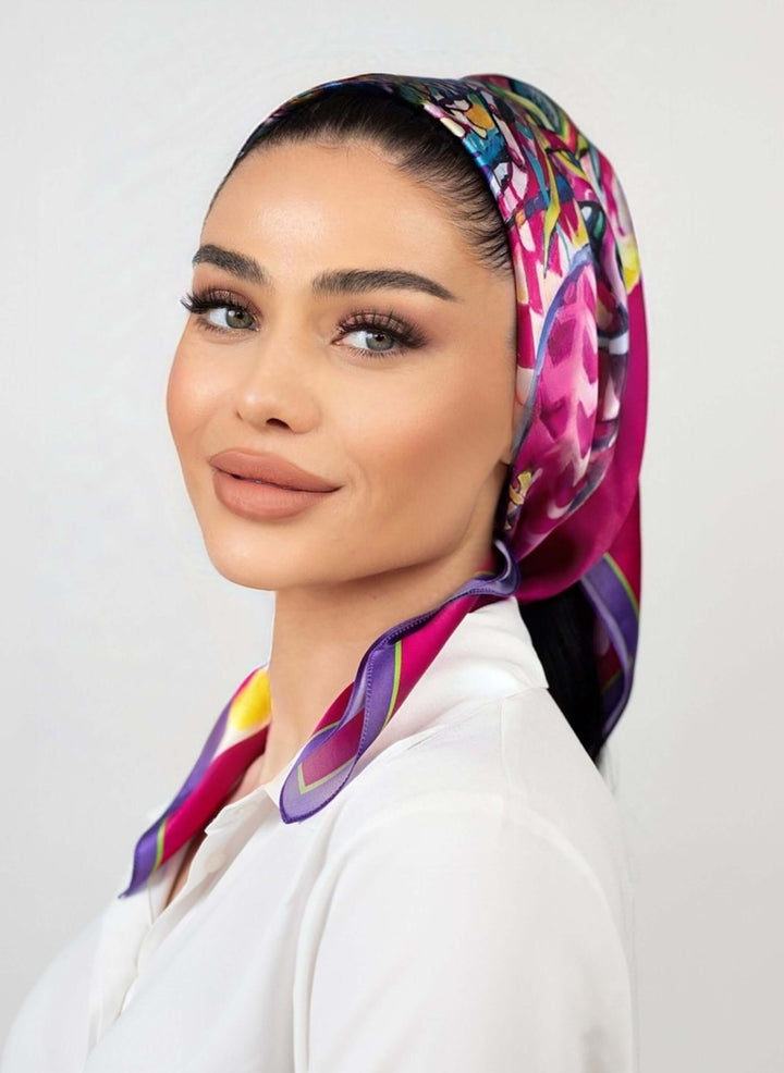 Elegant woman wearing a vibrant fuchsia designer silk scarf, showcasing a bold and stylish look.