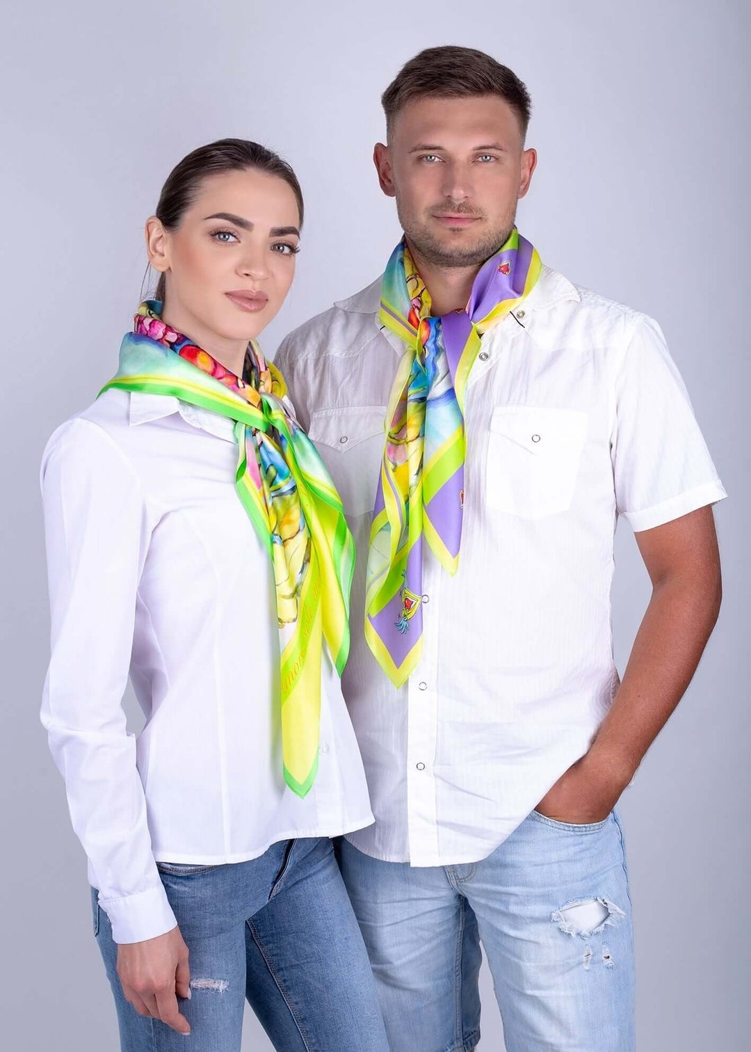 Zwei Modelle tragen einen leuchtend gelben Seidenschal mit fröhlichen Vogelmotiven, perfekt für jedes Outfit.