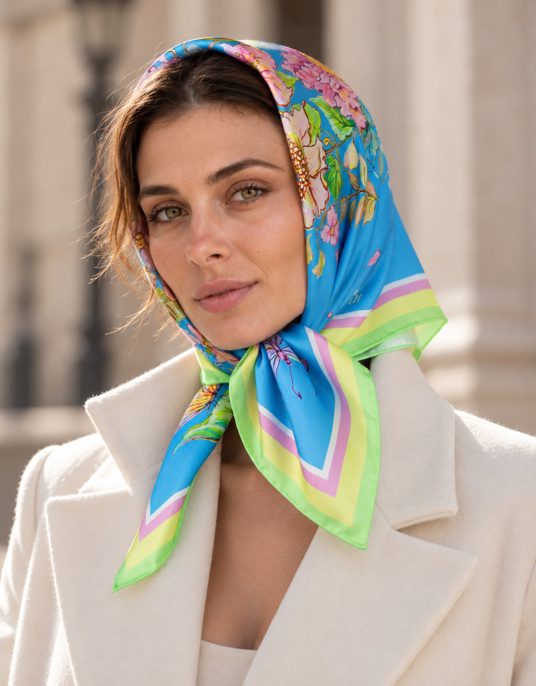 Frau trägt einen blauen Designer-Seidenschal von Feinblatt mit Blumenmuster als Kopftuch, unter dem Kinn gebunden.