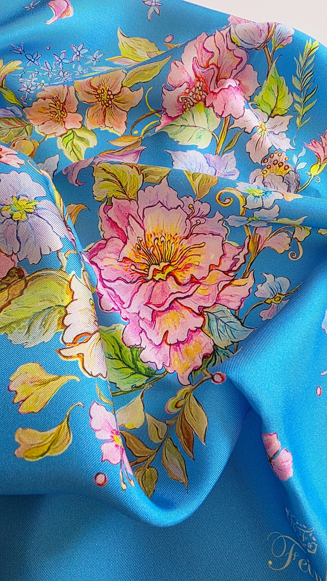 Detailaufnahme des Designer-Seidenschals „Herz aus Blumen“ in Blau aus 100 % Twill-Seide mit feiner diagonaler Webstruktur und floralem Originaldesign von Iryna Feinblatt.