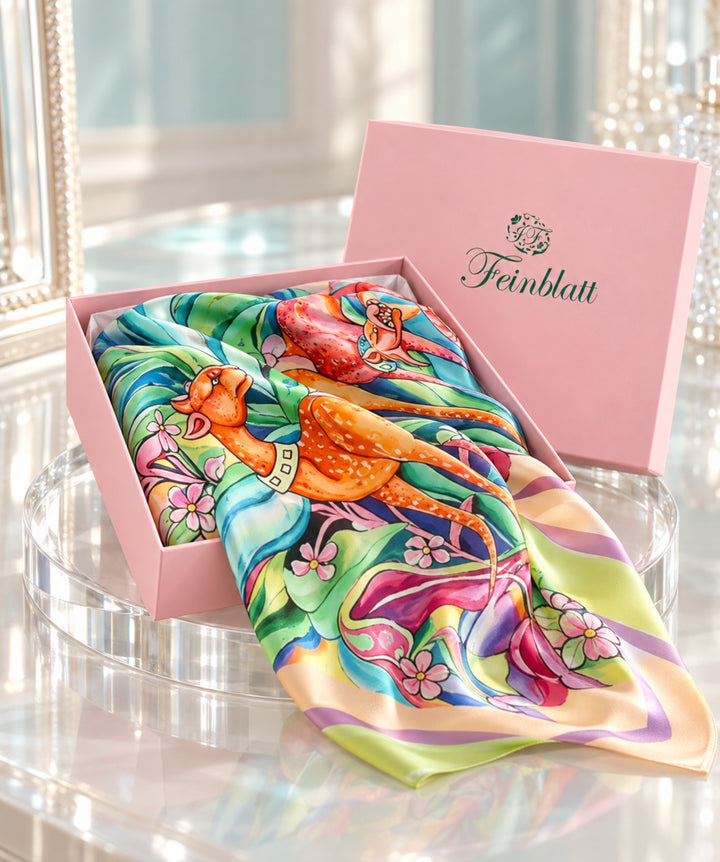 Designer-Seidenschal Leoparden Multicolor aus Seidensatin in einer offenen rosa Feinblatt Geschenkbox.