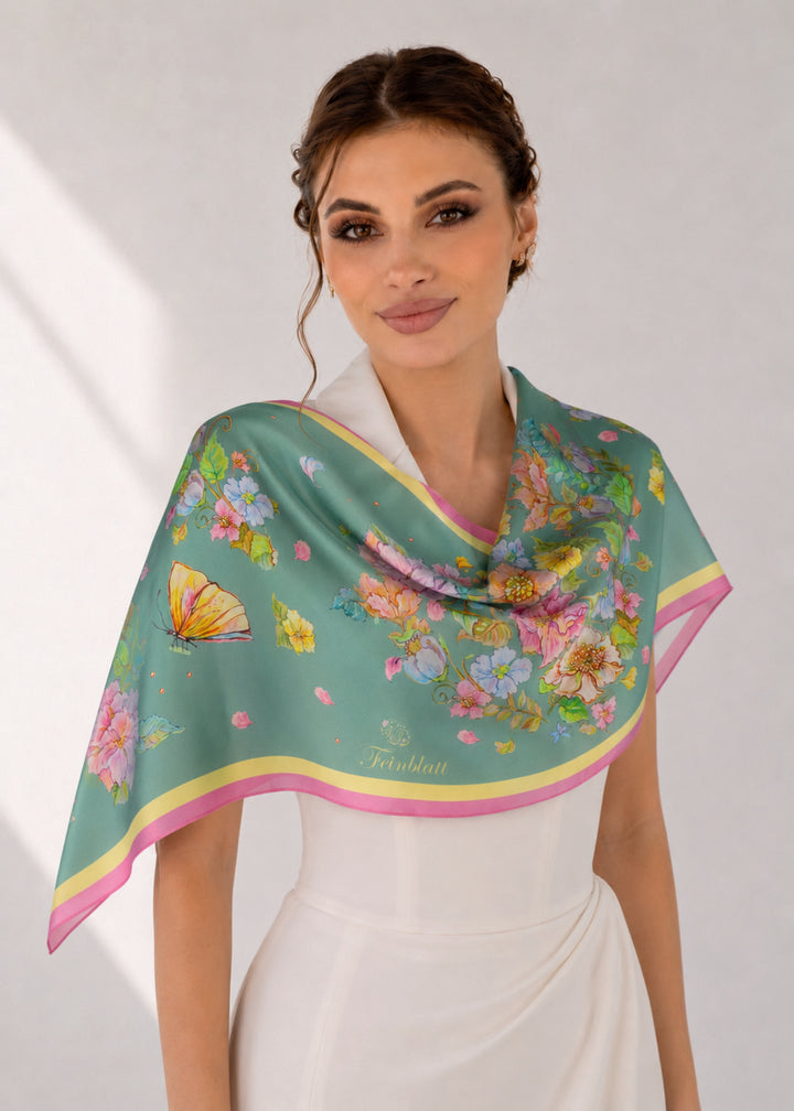 Designer-Seidenschal in Mint mit Blumen und Schmetterlingen elegant über den Schultern getragen