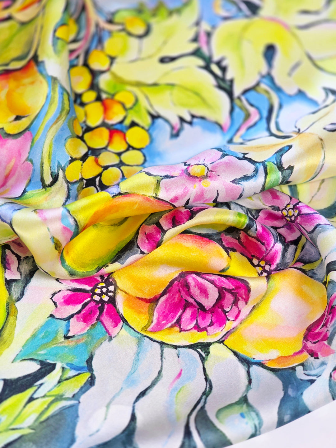 Detailaufnahme des Designer Seidenschals Sunny Italy aus italienischer Seide mit floralem Motiv in Neon Grün, Gelb und Pink von Iryna Feinblatt.