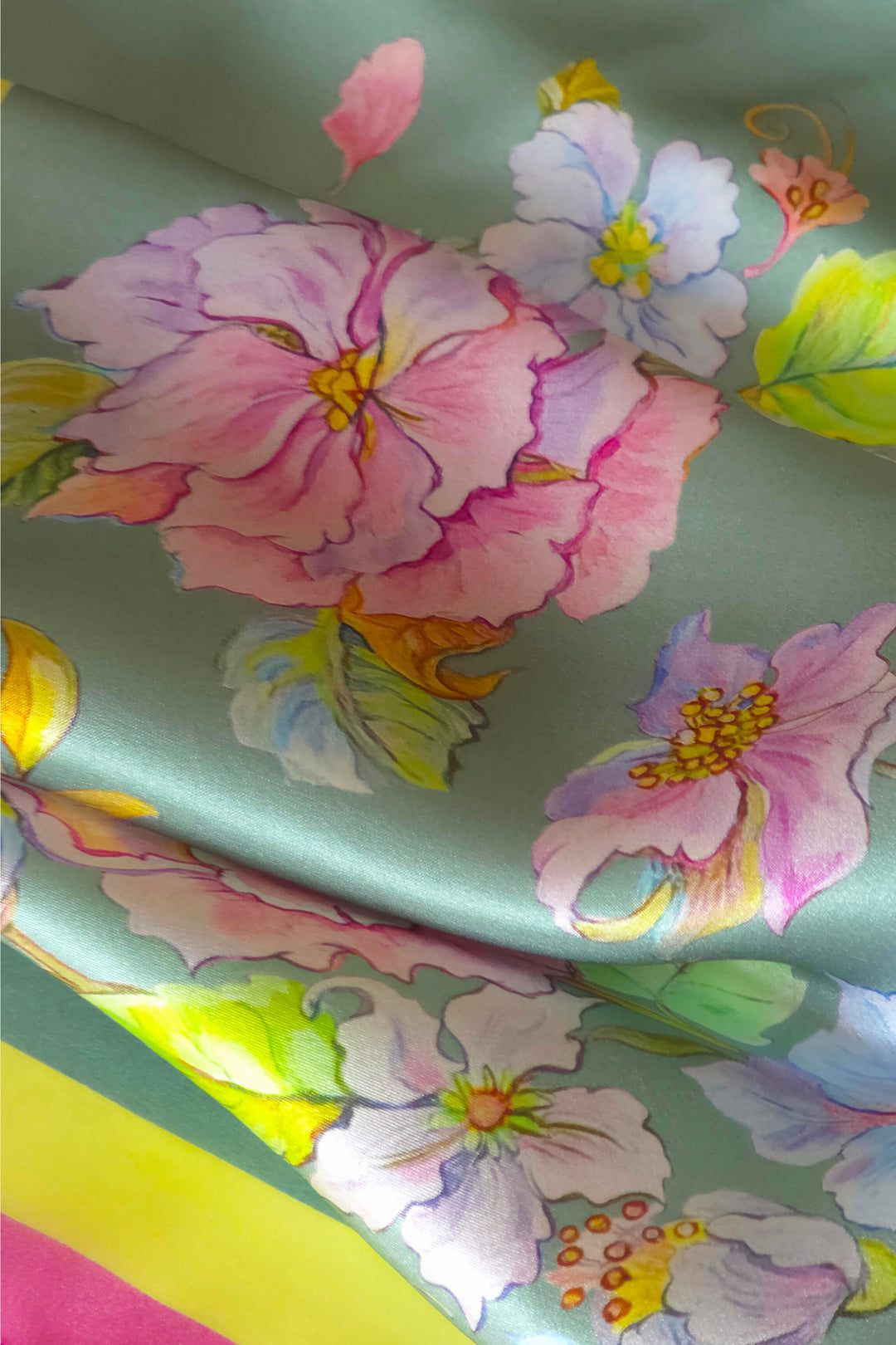 Detailaufnahme des Designer-Seidenschals Herz aus Blumen in Mint mit feiner Seidenstruktur, floralem Motiv und pink-gelber Bordüre