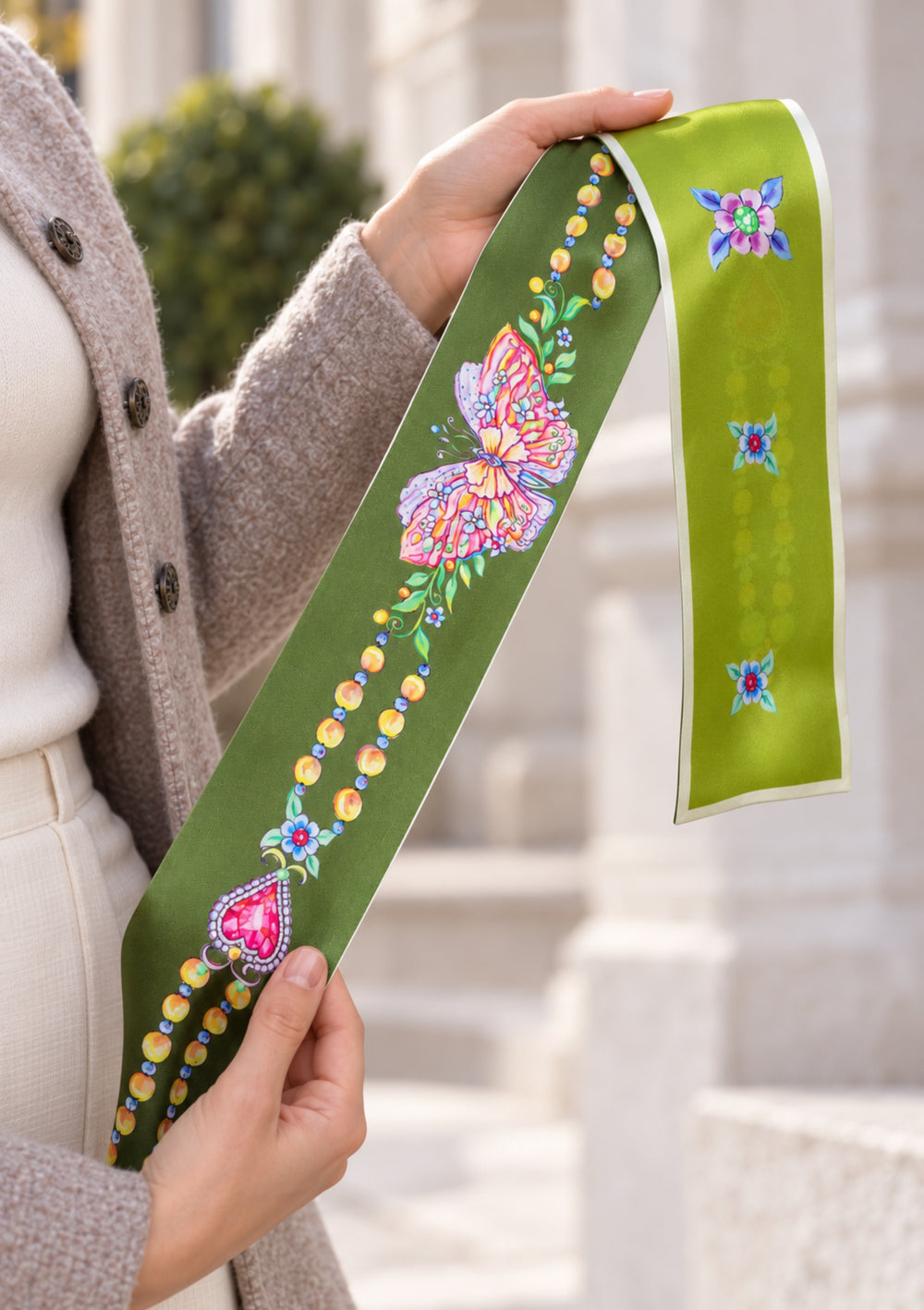 Hände halten einen oliv und limettengrünen Seidenschal mit buntem Schmetterling, Blumen und aufgedruckten Perlenketten.









    











напиши назву файлу і альт тегі. яке зображення більш підходить до сайту













Працював 15 с




Для сторінки товару я обрала б перше зображення. Шаль краще виділяється на однотонному жакеті, а композиція зосереджує увагу на її малюнку. Друге підійде як додаткове фото, щоб показати шаль у повсякденному образі.
Назви й alt-тексти німецькою:
Зображення	Назва ф