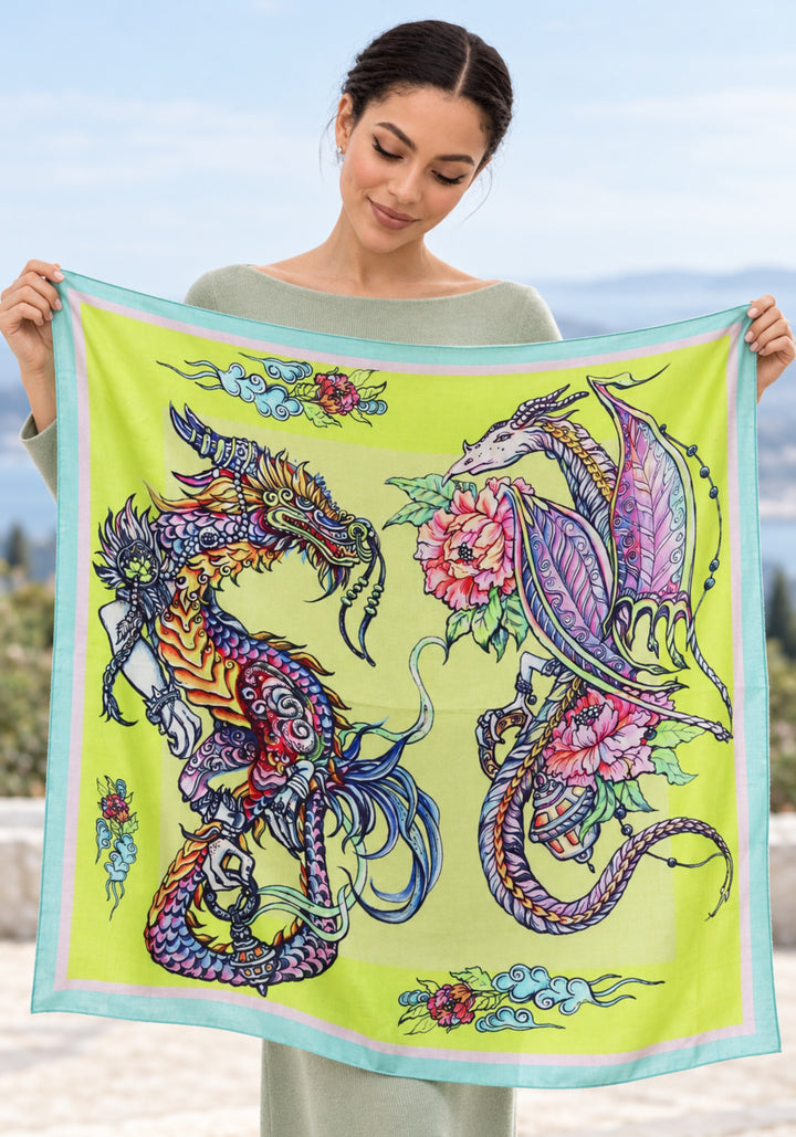 Frau hält den gelben Kaschmirschal Dragons von Iryna Feinblatt ausgebreitet und zeigt zwei Drachen und rosa Pfingstrosen.