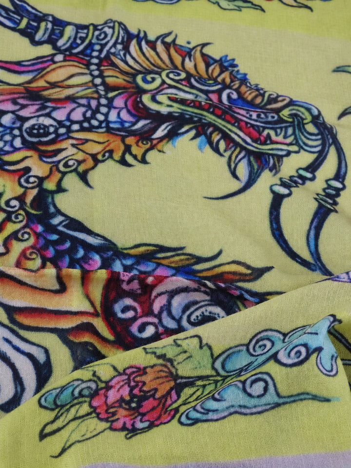 Nahaufnahme des gelben Kaschmirschals Dragons von Iryna Feinblatt mit Drachenkopf, Blütenmotiv und feiner Gewebestruktur.