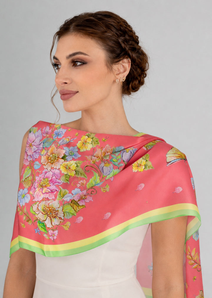 Langer Designer-Seidenschal „Herz aus Blumen“ in Korallenrot über den Schultern getragen