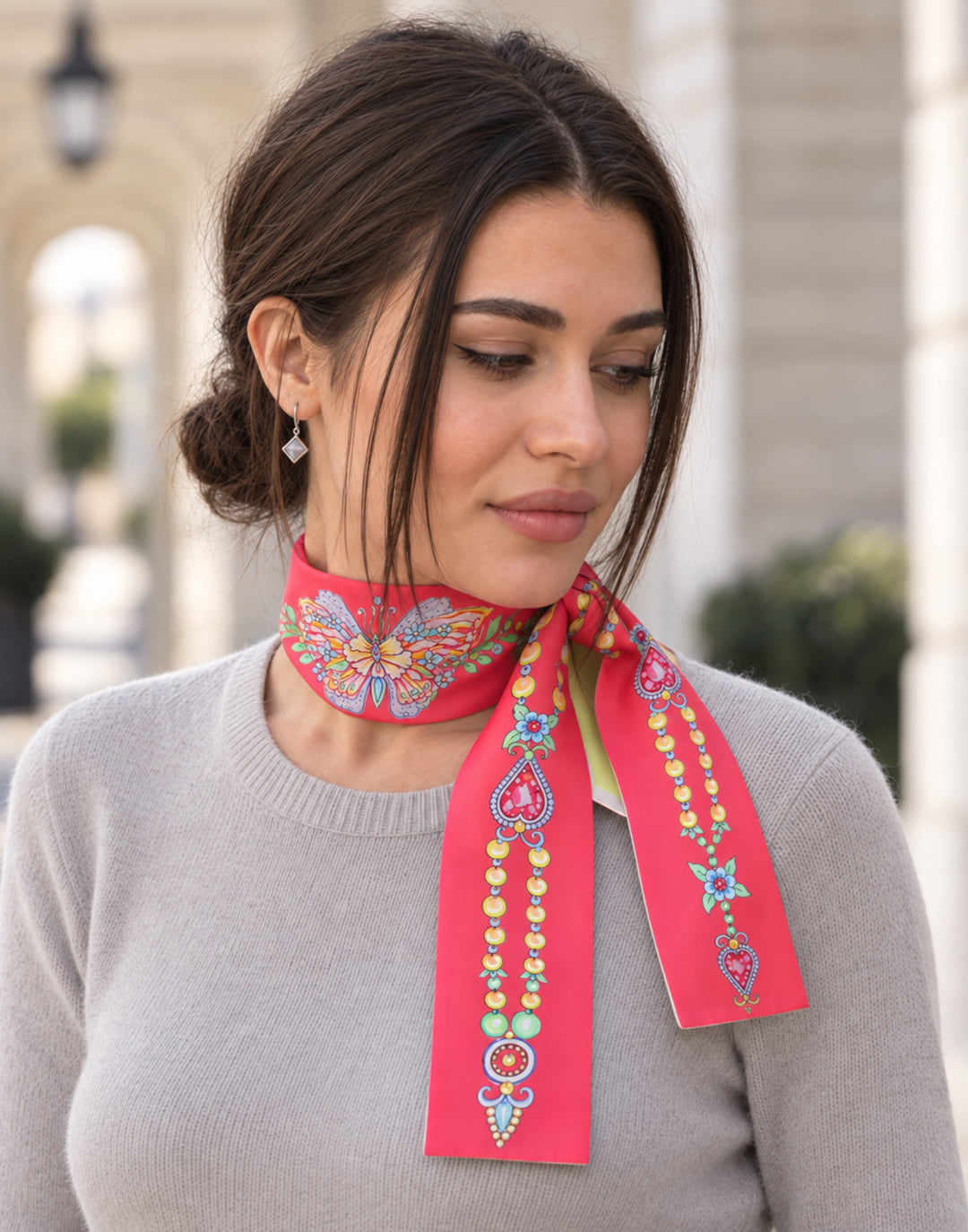 Rotes Seidentuch mit Schmetterling und Schmuckmotiven elegant um den Hals getragen