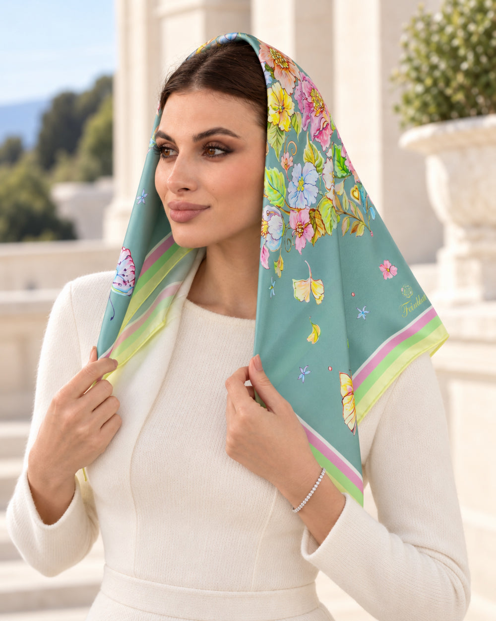 Frau trägt das mintfarbene Seidenkopftuch „Herz aus Blumen“ von Feinblatt mit floralem Motiv aus 100 % Seidensatin.