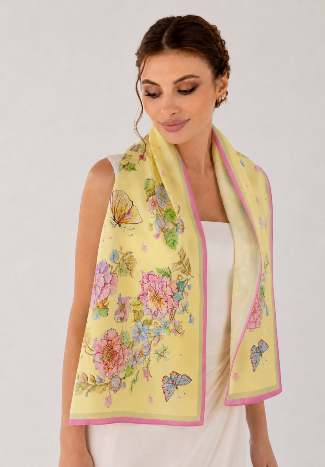Model im weißen Kleid trägt den gelben Feinblatt-Seidenschal Herz aus Blumen locker über den Schultern