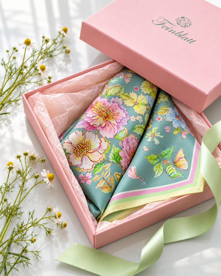 Gefaltetes Seidentuch mit rosa Blumen in einer rosafarbenen Feinblatt Geschenkbox